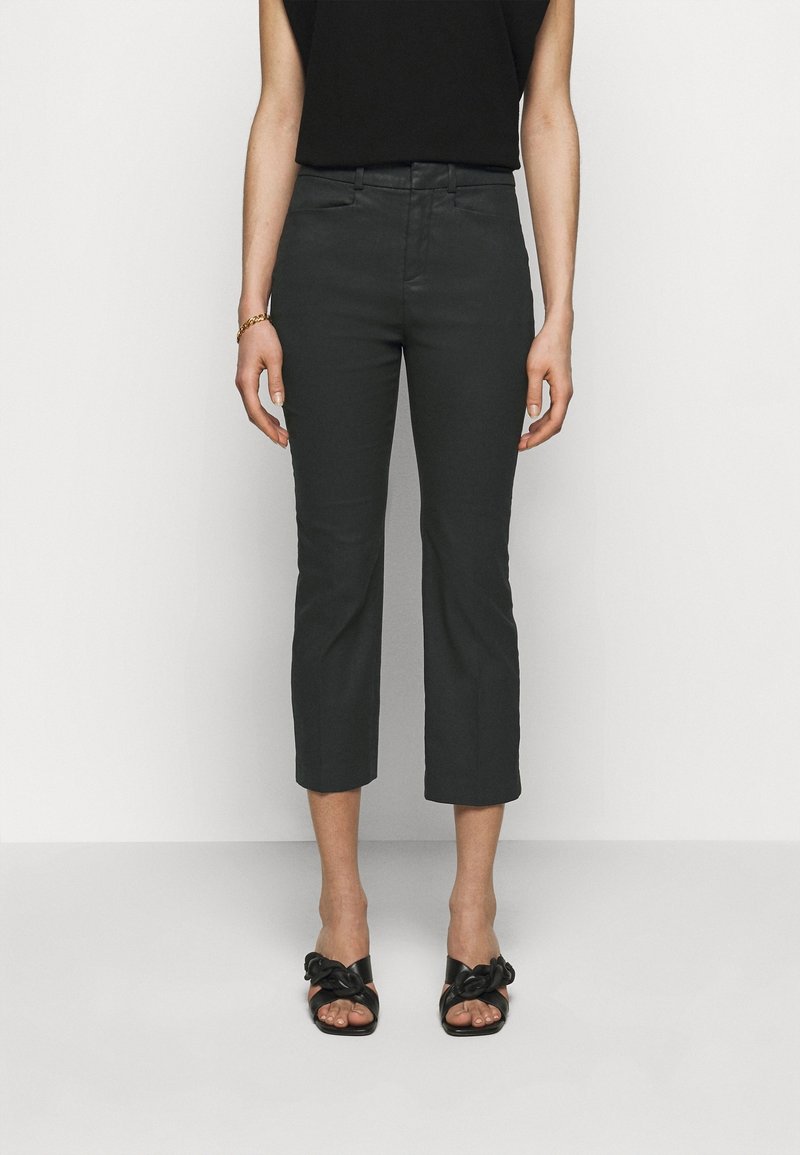Black cropped trousers with a slim fit, made of smooth fabric. Features a mid-rise waist and neatly finished hems. Paired with black sandals.