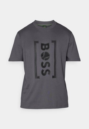 Pilkas medvilnės marškinėliai su tekstūruotu juodu „BOSS“ logotipu. Trumpi rankoves, apvalus iškirpimas ir minkšta medžiaga su subtiliu blizgesiu.