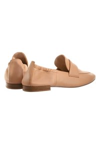 Beige Leder-Slippers mit einer abgerundeten Zehenpartie und einem gefalteten Riemen. Das Design verfügt über einen niedrigen Holzabsatz und ein elastisches Band an der Rückseite für zusätzlichen Komfort.