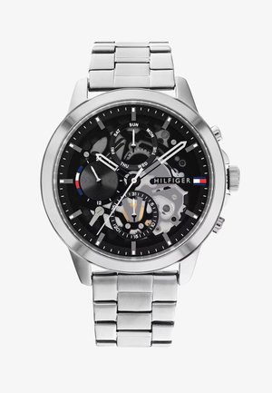Chronograph-Uhr mit schwarzem Zifferblatt, silbernem Edelstahlgehäuse und -armband. Zu den Funktionen gehören Datums- und Wochentagsanzeigen sowie ein sichtbar mechanisches Uhrwerk.