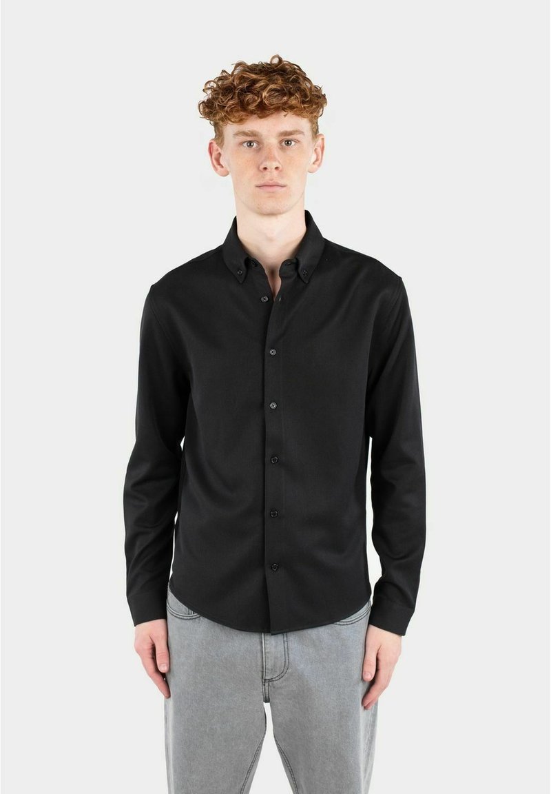 Svart langermet skjorte med krage som kan kneppes, laget av glatt stoff, med en figursydd design og frontknapping.