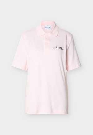 Ανοιχτό ροζ κοντομάνικο πόλο με δύο κουμπιά και μαύρο καλλιγραφικό λογότυπο "Lacoste" στο αριστερό στήθος.