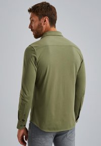 Langsleeve shirt in een olijfgroene katoenmix, voorzien van een kraag, met knoopsluiting bij de mouwen en een afgeronde onderkant. Glad materiaal met een getailleerd ontwerp.