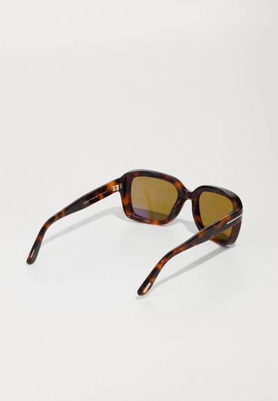 Braune Schildpatt-Sonnenbrille mit rechteckigen Gläsern, goldenen Akzenten an den Bügeln und gebogenen Armen. Die Gläser haben einen Farbverlaufstönung.