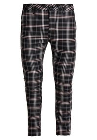 Svart rutig byxor med ett mönster av vita, rosa och grå linjer. Sitter tajt med en klassisk knapp- och dragkedjestängning.