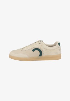 Zapatilla beige de corte bajo con suela de goma, cordones crema, logo verde curvo en el lateral y marca Colmar en el área del talón.