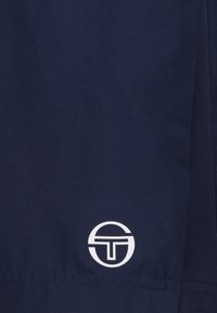 Tessuto blu navy con una superficie liscia, presenta un logo bianco in basso a destra, circolare con lettering stilizzato al centro.