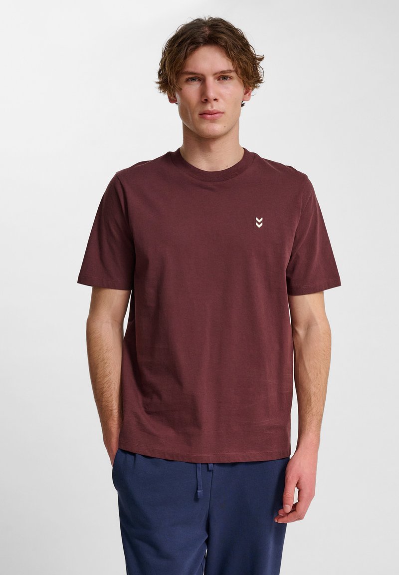 Bordeaux bomulds t-shirt med rund hals og korte ærmer, prydet med et lille hvidt zigzag-mønster på brystet. Glat tekstur.
