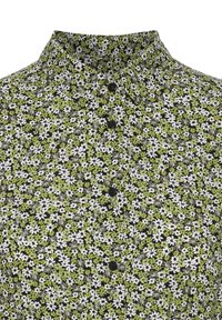 Camicia a bottoni floreale con un motivo verde, bianco e nero. Presenta un colletto a punta e cinque bottoni neri. Tessuto dalla consistenza liscia.