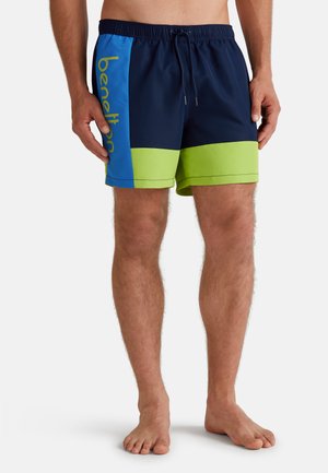 Námořnické modré plavky s bočními panely v zelené a modré; elastický pas s tkaničkou; na boku se nachází vytištěné logo "benetton" v žluté barvě.
