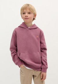 Roze hoodie gemaakt van zacht materiaal met een grote buidelzak aan de voorkant en een kap met trekkoorden. Heeft een klein geborduurd doodshoofdlogo op de borst.