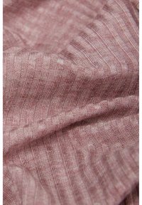 Textil i en mjuk rosa nyans med ett subtilt randigt mönster, som har en fin, lättstickad textur och en lätt lyster.