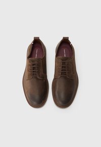 Brown leather shoes with a smooth texture, lace-up design, round toe, and rubber sole. Interior features a branded insole.