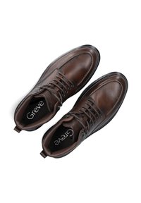 Bruine leren schoenen met een gestructureerde afwerking, voorzien van een ronde neus, gesloten vetersysteem en een slanke zwarte loopzool. Logo zichtbaar aan de binnenkant.