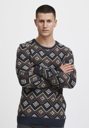 Pulover s svetlomornarsko modro podlago z diamanti v beli, rjavi in oranžni barvi. Pletena tekstura z rebrastimi manšetami in robom.