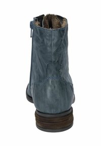 Stivale alla caviglia in pelle blu con punta rotonda, cerniera laterale, fodera in pelliccia sintetica e tacco in legno impilato; presenta accenti cuciti sul retro.