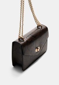 Clutch od smeškanog zmijskog krzna smeđe boje s zlatnom lancem za nošenje, s dodatkom zlatnog kopčanja. Strukturiran pravokutni oblik s teksturiranom površinom.