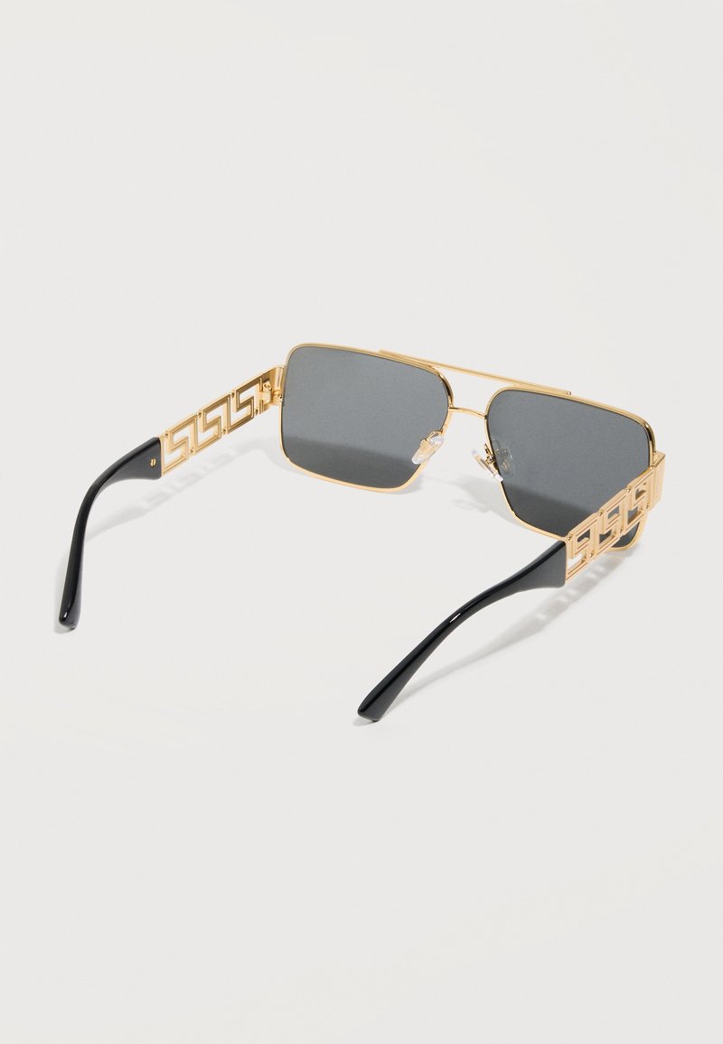 Gold-framed square sunglasses with black temple tips and a geometric cutout pattern on the arms, featuring dark gray lenses.