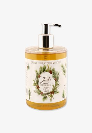 Pump dispenser bottle for liquid soap, clear with a golden liquid, decorative label featuring green pine branches and pine cones.