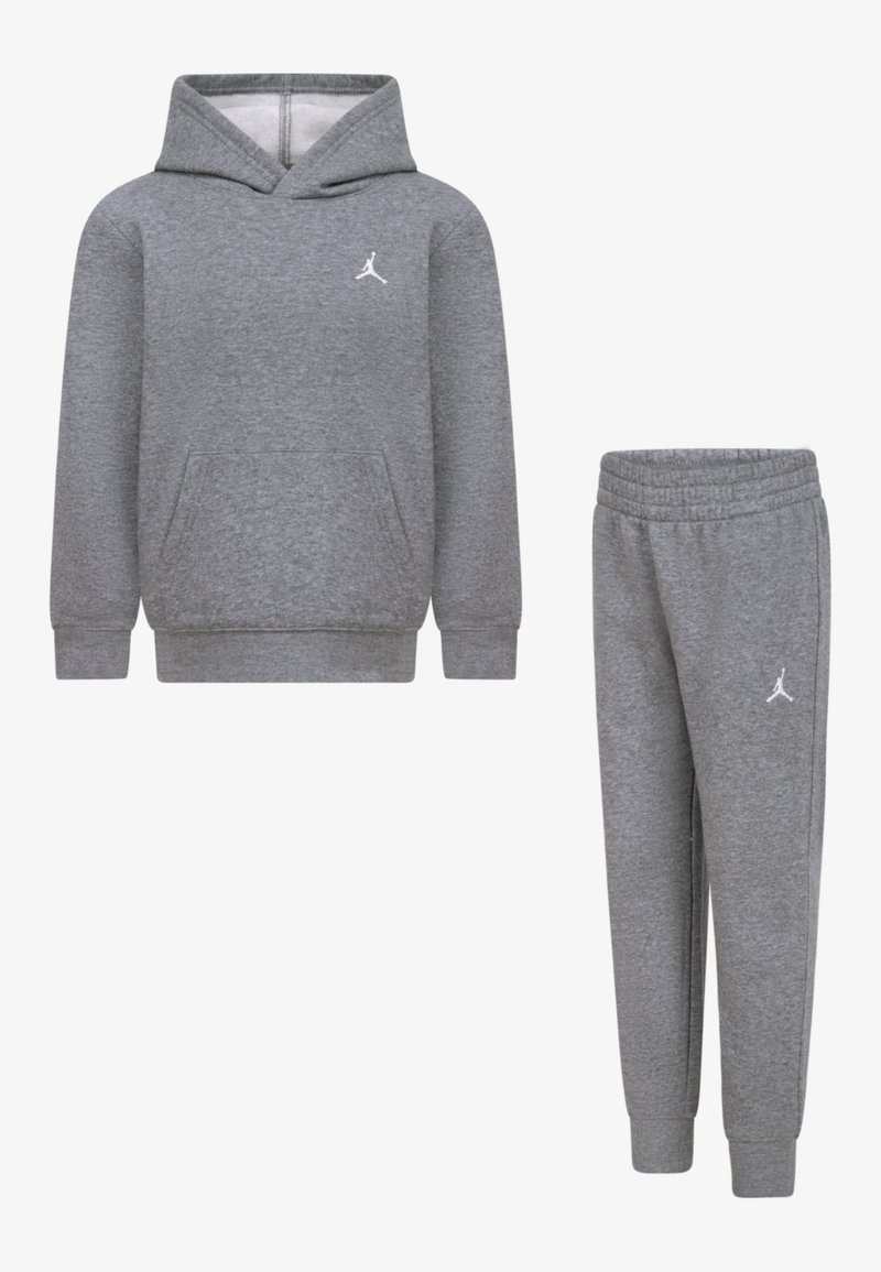 Grijze hoodie en joggingbroek set, gemaakt van zachte stof. De hoodie heeft een voorzak en een wit logo, terwijl de broek een elastische tailleband heeft.