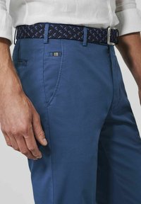 Heren blauwe katoen chino's met zijzakken, gecombineerd met een marineblauwe geweven riem met blauwe accenten en een metalen gesp.