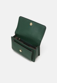 Zelená kožená peněženka s texturovaným povrchem, obsahující zlaté zapínání na patent a dělený interiér včetně zipové kapsy.