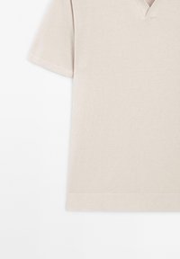 Top in maglia beige a maniche corte con scollo a V e orlo ribbed su fondo e polsini, esposto su uno sfondo bianco.