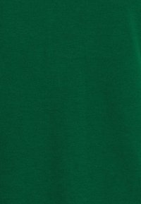 T-shirt in cotone verde con una texture liscia e un design semplice. Presenta un collo rotondo e maniche corte. Nessun motivo o dettaglio.
