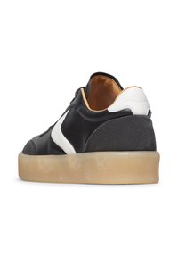 Sneaker in pelle nera con accenti bianchi e interno beige. Caratterizzato da una linea bassa, punta tondeggiante e suola in gomma testurizzata.