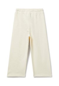 Krémově zbarvené široké kalhoty s elastickým pasem, vystavené položeny na bílém pozadí.