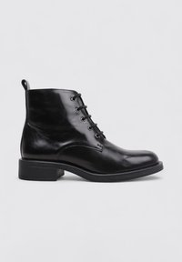 Botte cheville en cuir noir avec une finition lisse, lacets à l'avant, bout rond et un petit talon bloc. Comprend une languette à l'arrière.