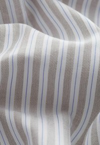 Kangas yang menampilkan garis-garis bergantian coklat dan biru muda di latar belakang putih, dengan permukaan yang sedikit tekstur dan jatuhan yang lembut.