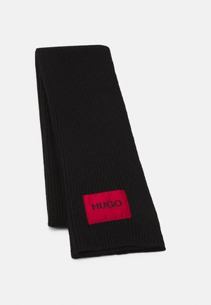 Sort ribstrikket halstørklæde foldet, med et rødt rektangulært mærke med sort "HUGO" tekst nær den ene ende.