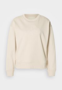 Kremowy sweatshirt wykonany z miękkiej tkaniny, z teksturowanym, wypukłym okrągłym wzorem z przodu oraz ściągaczami na mankietach i dole.
