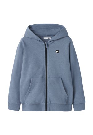 Hellblauer Kapuzenpullover mit Reißverschluss, Vordertaschen, gerippten Bündchen und Bund sowie einem kleinen schwarz-weißen runden Logo auf der linken Brust.