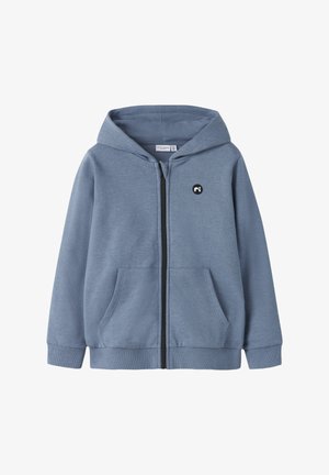 Hellblauer Kapuzenpullover mit Reißverschluss, Vordertaschen, gerippten Bündchen und Bund sowie einem kleinen schwarz-weißen runden Logo auf der linken Brust.