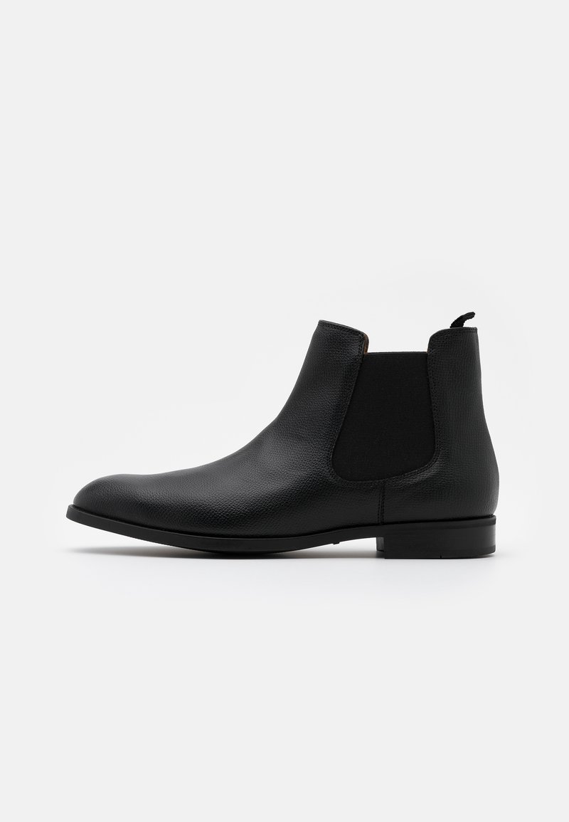 Bottine Chelsea en cuir noir montant à la cheville avec panneau latéral élastique et languette de traction, vue de côté sur fond blanc.