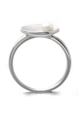Zilveren ring met een platte, ronde bovenkant die een enkele kleine witte parel vasthoudt op een witte achtergrond.