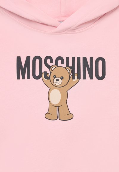 Hoodie rose avec un motif de ours en cartoon marron avec un ventre crème, et le texte "MOSCHINO" en noir au-dessus du design.