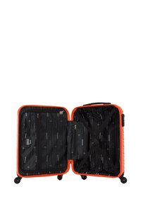 Maleta rígida naranja con una superficie texturizada. El interior cuenta con un forro negro, correas cruzadas y compartimentos con cremallera. Cuatro ruedas giratorias.