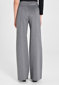 Pantaloni grigi a gamba larga con righe verticali, caratterizzati da una vita alta, linee pulite e una texture liscia adatta per abbigliamento formale.