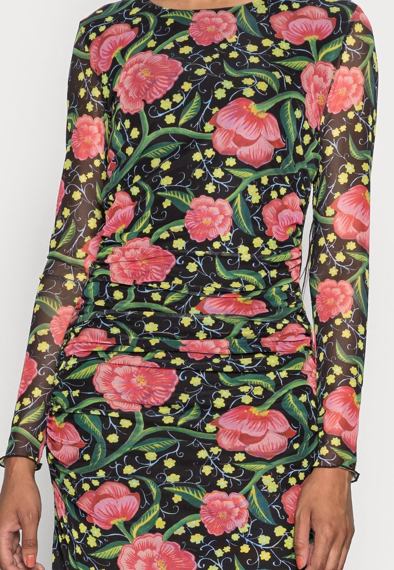Robe à manches longues en tissu noir transparent avec des motifs floraux roses vibrants et un feuillage vert. Détails froncés sur les côtés.