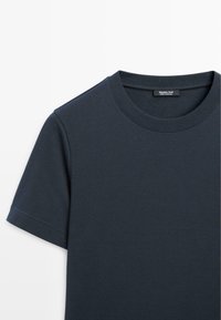T-shirt en coton bleu foncé avec un col rond, des manches courtes et une étiquette portant "Massimo Dutti" au col. Texture lisse.