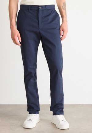 Navy blue, slim-fit chinos made of lightweight fabric, featuring a front button closure, seamless pockets, and tapered leg design.
