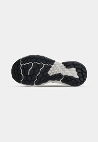 Shoe sole with a honeycomb pattern, featuring black and white rubber materials. Tread offers textured grip and varying surface shapes.