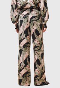 Pantaloni neri leggeri con un audace motivo botanico in verde, rosa e crema. Design a vita alta con una fascia elastica in vita.