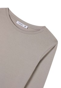 Camicia a maniche lunghe di colore beige chiaro inFabric soft. Presenta un colletto girocollo e una piccola etichetta con "Terranova" e la taglia "S" all'interno del colletto.
