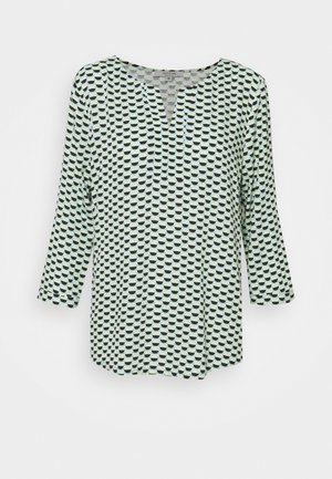 Chemise à manches longues en tissu vert clair avec un motif géométrique noir et bleu, dotée d'un décolleté en V et d'une coupe décontractée.