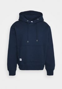 Sweat à capuche bleu marine en mélange de coton. Dispose d'une poche kangourou à l'avant, d'une capuche avec cordon de serrage et d'un logo discret à l'ourlet.