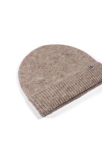 Knitted beanie in light brown, featuring a ribbed cuff and soft texture. Includes a small woven label on the side.